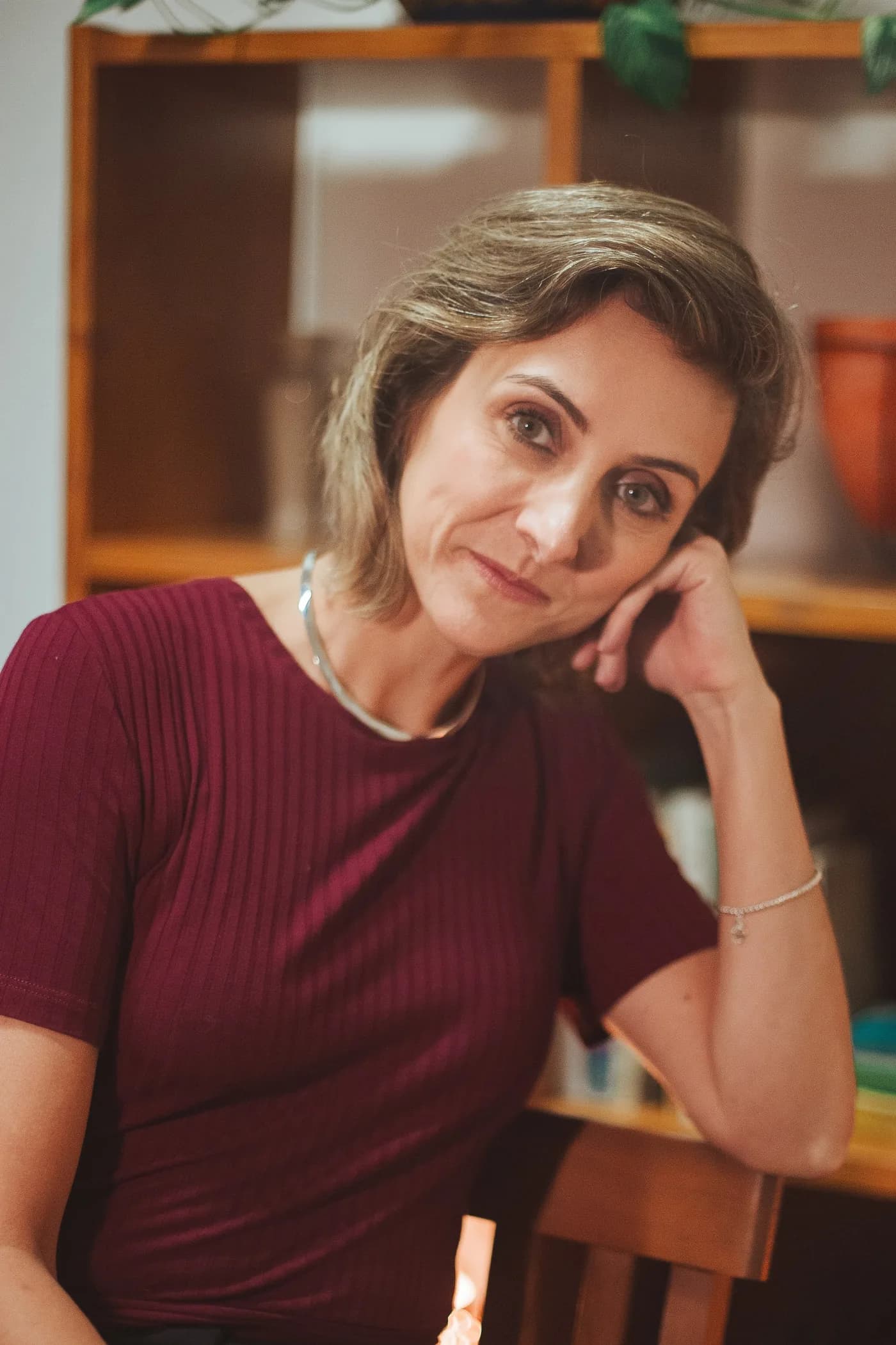 Caroline Reis Pereira, psicóloga clínica, com o rosto apoiado na mão