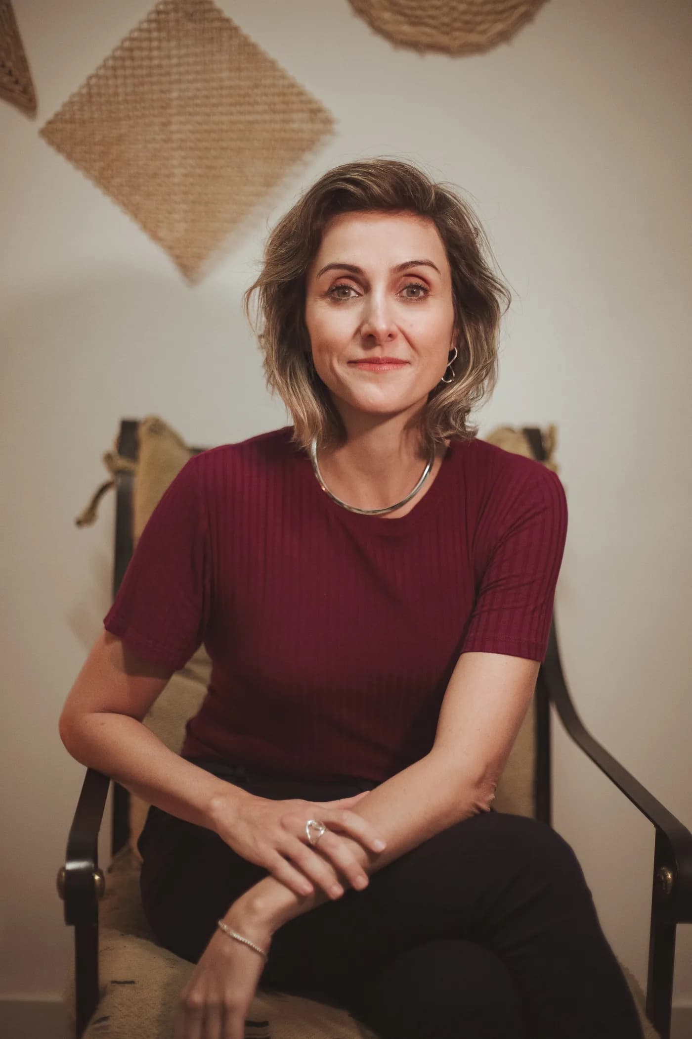 Caroline Reis Pereira, consultora de carreira, sentada em uma poltrona